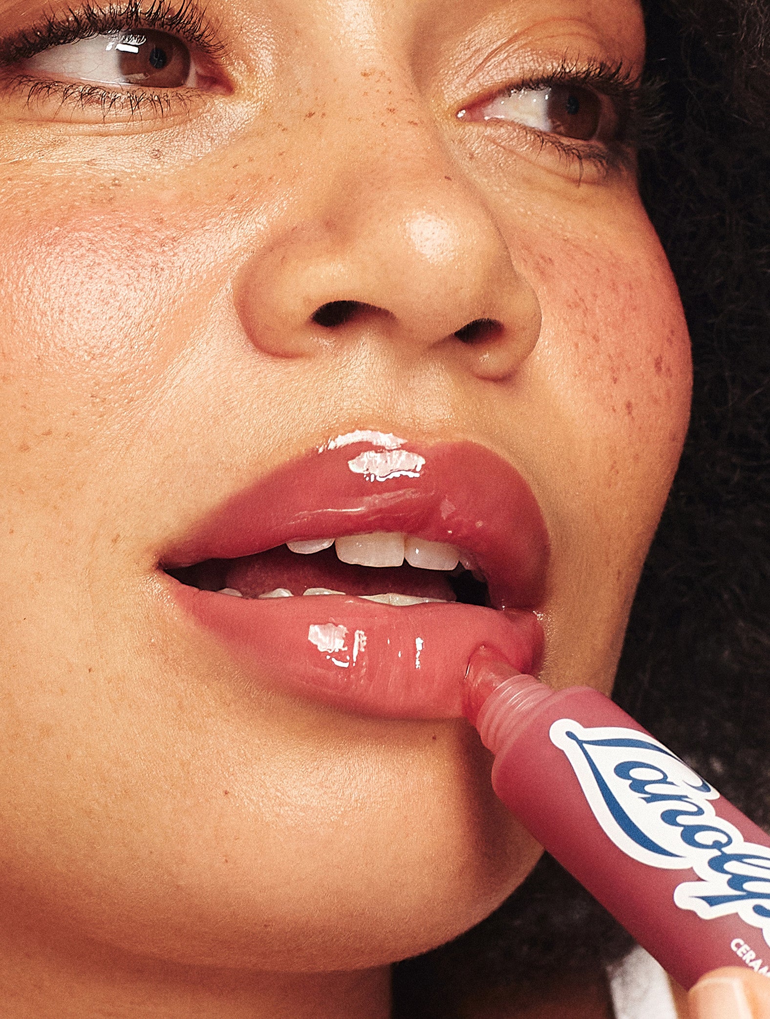 Lanolips Mocha Choca Ceramide Milkshake Balm being applied to lips, hydrating tinted lip balm with glossy shine