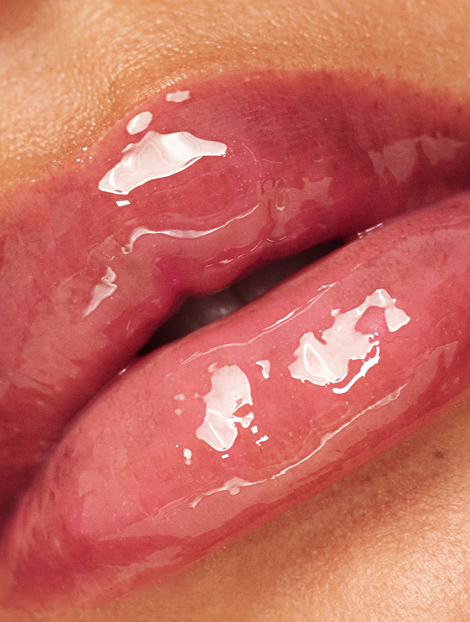 Extreme close-up of glossy, hydrated lips wearing Lanolips Milkshake Ceramide Balm in Raspberry Crumble, showing a sheer creamy raspberry tint with an intentionally less dense, soft and milkshake texture