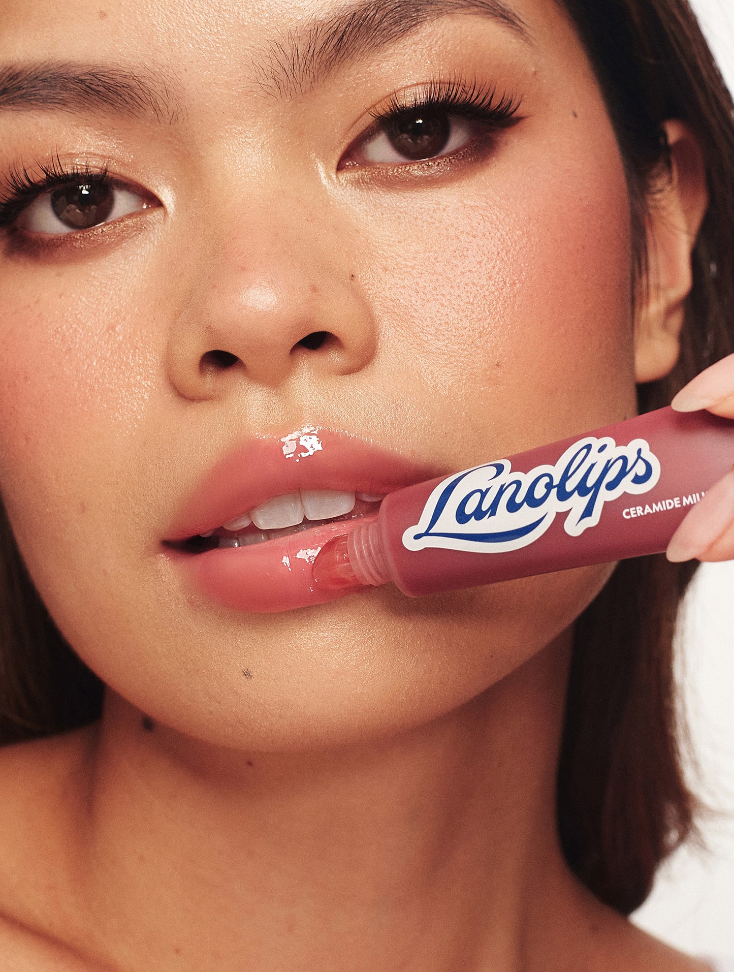 Model applying Lanolips Ceramide Milkshake Balm Mocha Choca, plummy chocolate mocha tinted lip balm with a sweet and creamy finish