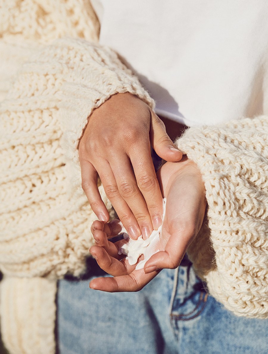 Model shot of model applying lanolips coconutter hand cream intense to her hands