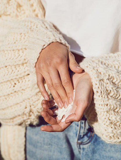 Model shot of model applying lanolips coconutter hand cream intense to her hands